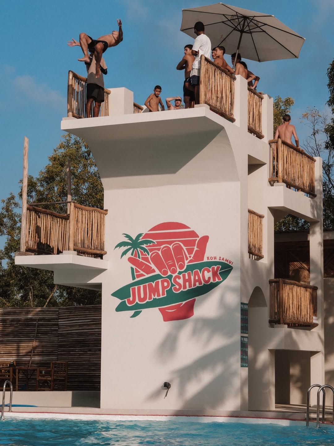 Jump Shack diving tower with guests mid-jump into the pool, Koh Samui